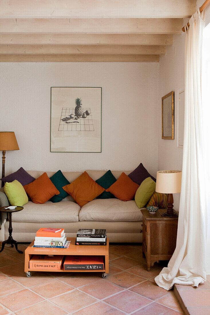 Multicoloured cushions on sofa with moveable coffee table in Castro Marim, Portugal