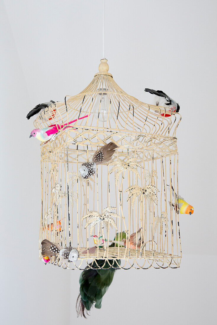 Modellvögel auf einem Vogelkäfig aus Metall in einem Haus in West Wittering, West Sussex, England
