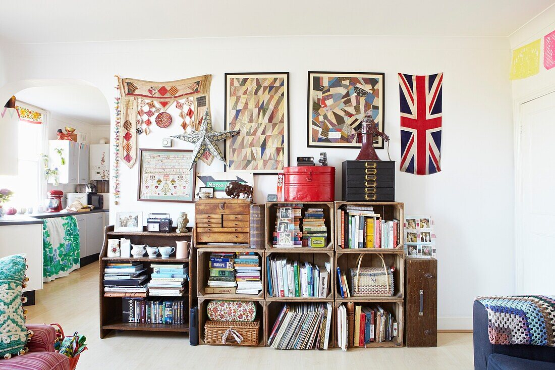Stacked crates for storage with artwork in living room of London family home,  England,  UK