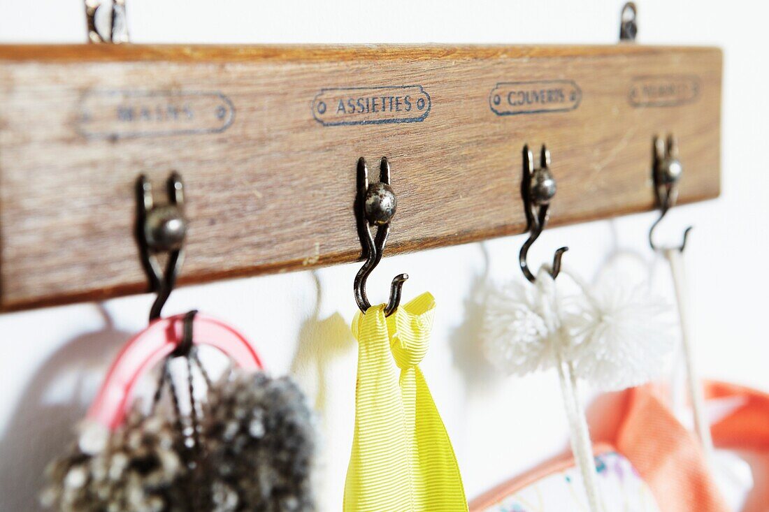 Wooden clothes hooks with French text in child's nursery of London family home,  England,  UK