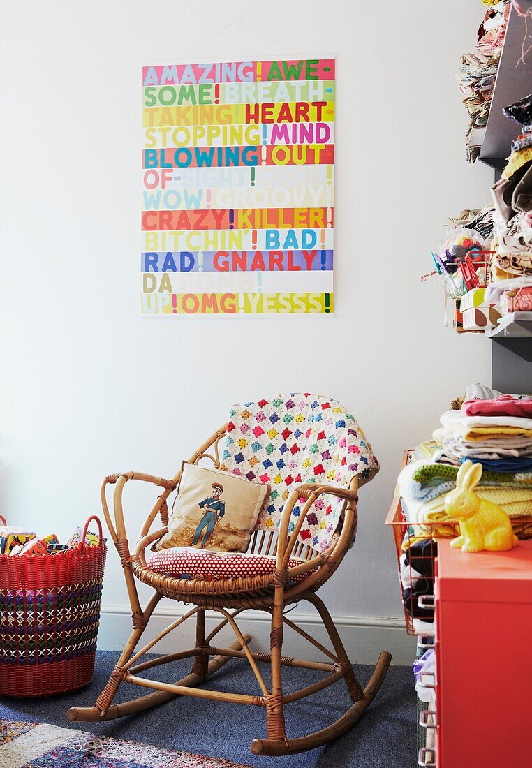 Schaukelstuhl und Poster mit Kleiderregalen im Kinderzimmer einer Londoner Familie, England, UK