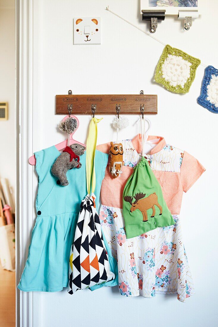 Kleider hängen an Wandhaken in Kinderzimmer, Londoner Einfamilienhaus, England, UK