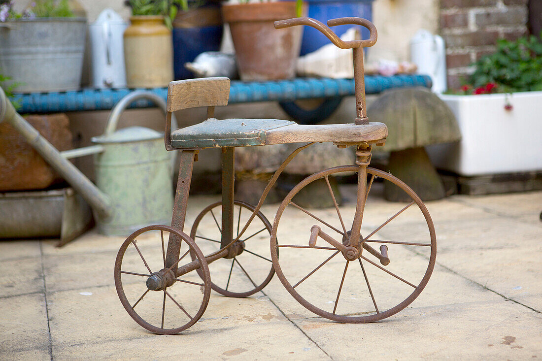 Child?s vintage tricycle in garden of Edwardian West Sussex townhouse England UK