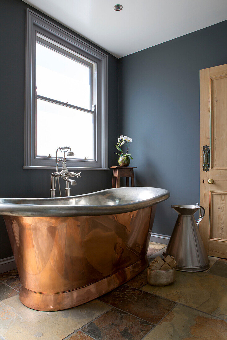 Freestanding copper bath with dark walls in Edwardian West Sussex townhouse England UK