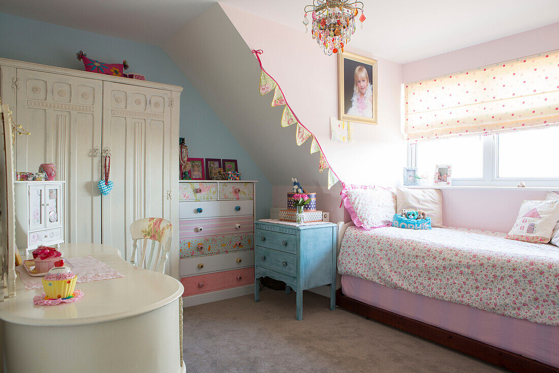 Mädchenzimmer mit gepunkteter, geblümter Bettdecke und upgecycelter Kommode in einem Familienhaus in West Sussex aus den 1950er Jahren UK