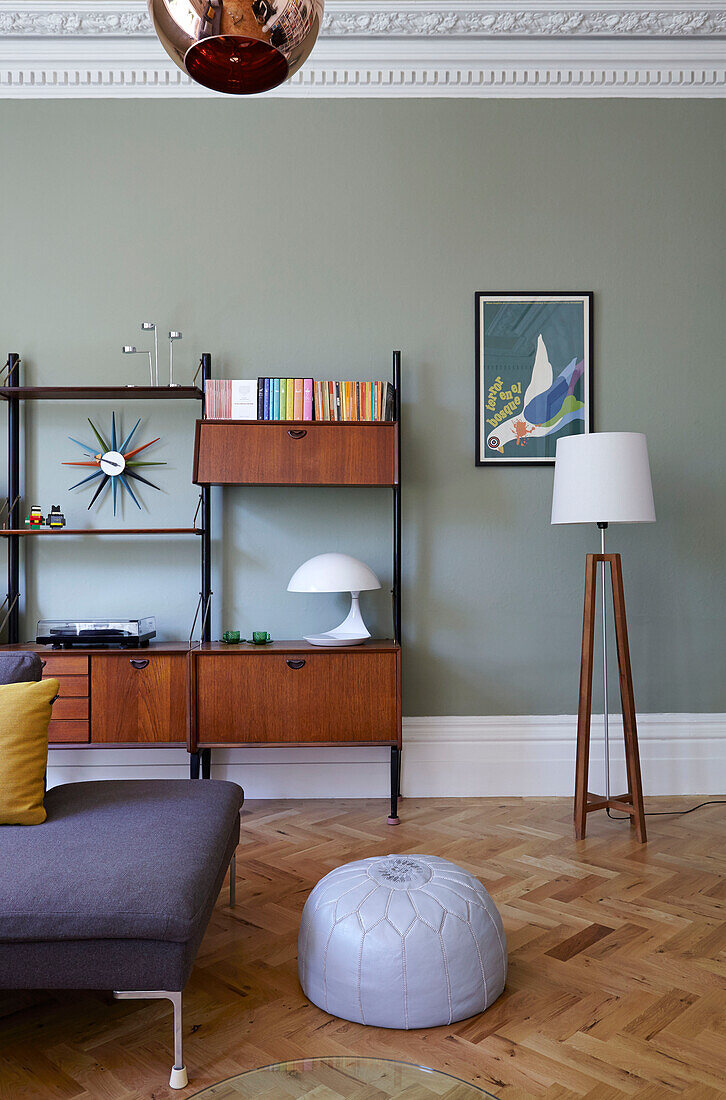 Leather pouf on parquet floor in living room with retro wooden side unit in London family home,  England,  UK