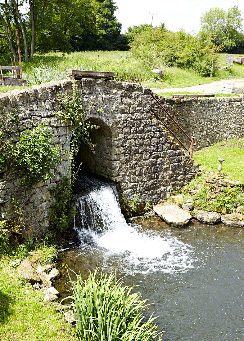 View of stone bridge and weir from window of rural UK farmhouse