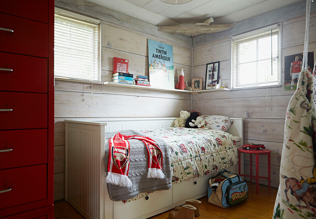 Venetian blinds at window of boys room with red filing cabinet in UK farmhouse