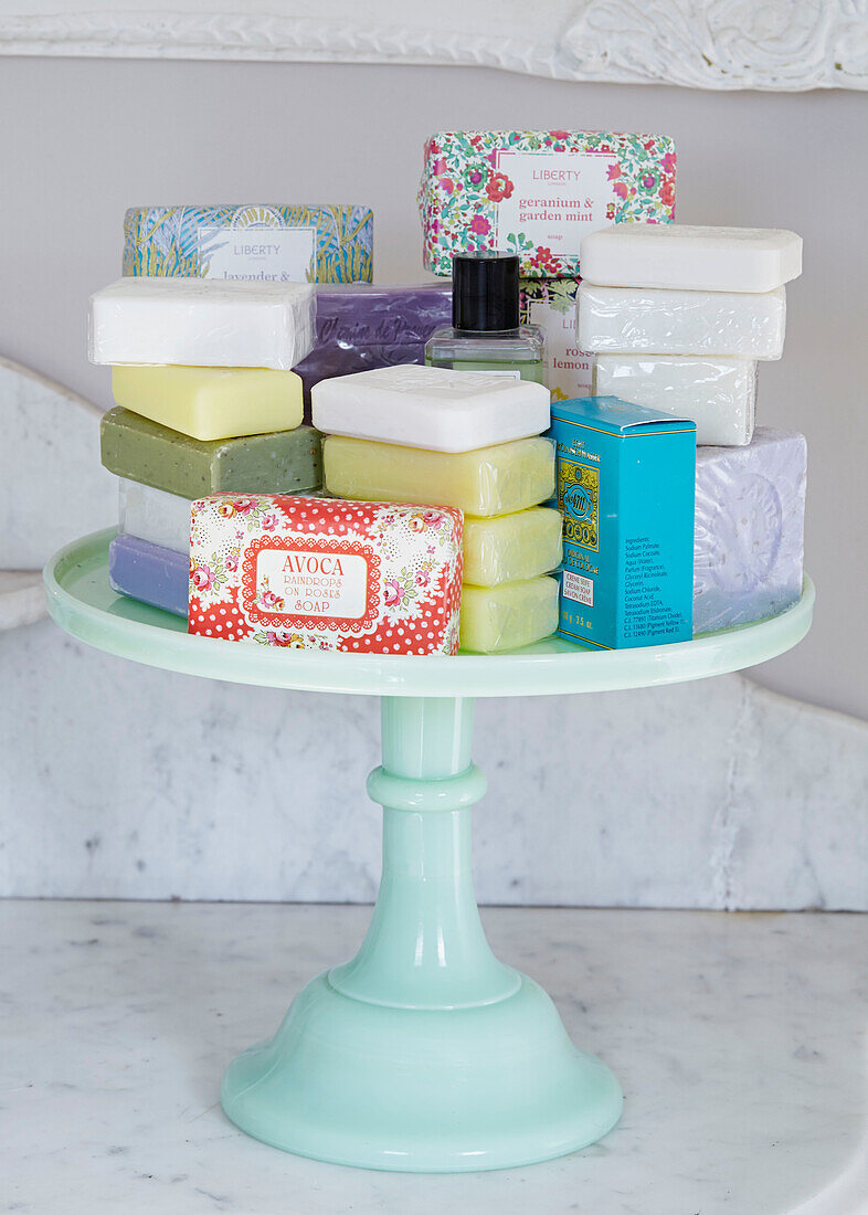 Assorted soaps on light green cake stand in UK farmhouse bathroom