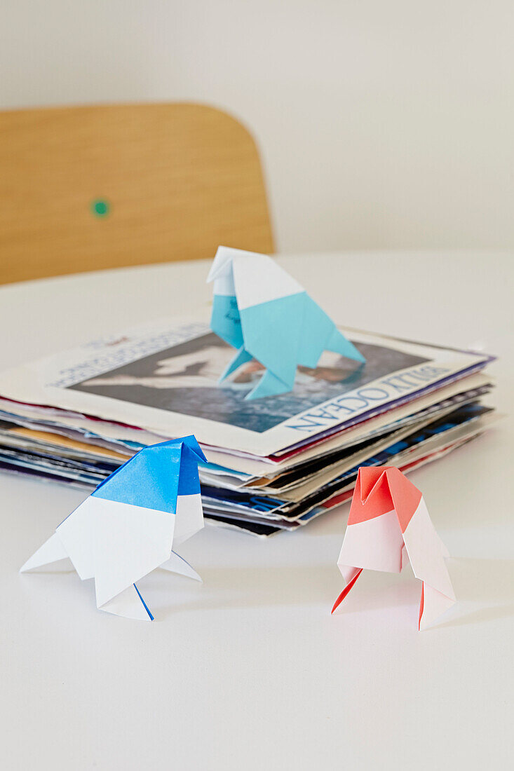 Origami-Vögel und Plattenhüllen auf dem Tisch in einem Londoner Haus, England, UK