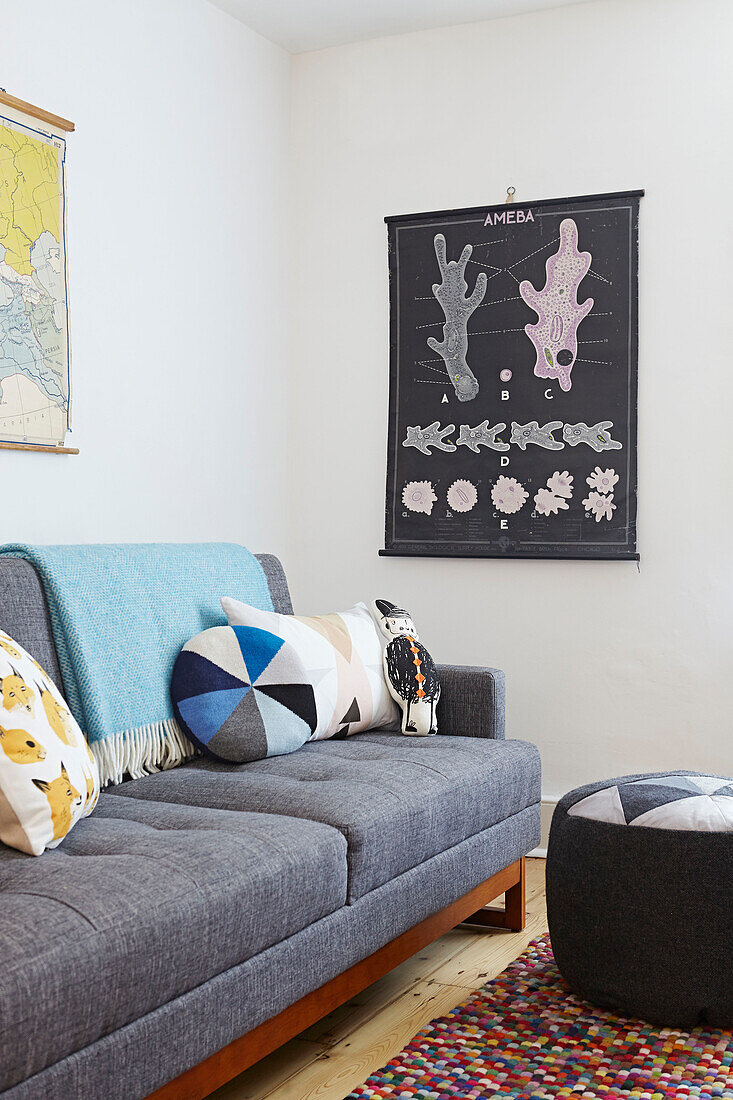 Kissen auf grauem Sofa mit Kunstwerken im Wohnzimmer eines Londoner Hauses England UK