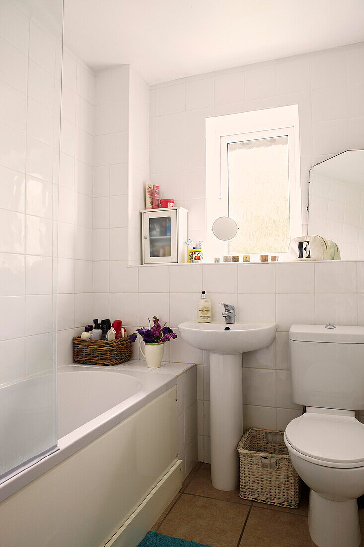 Weidenkörbe im weiß gefliesten Badezimmer eines Hauses in Birmingham England UK