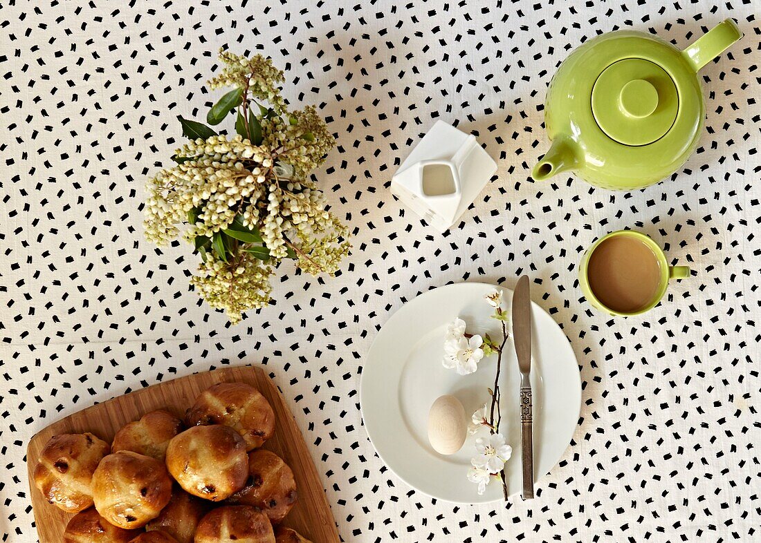 Schnittblumen und Teekanne mit Hot Cross Buns auf dem Frühstückstisch in einem Londoner Haus England UK