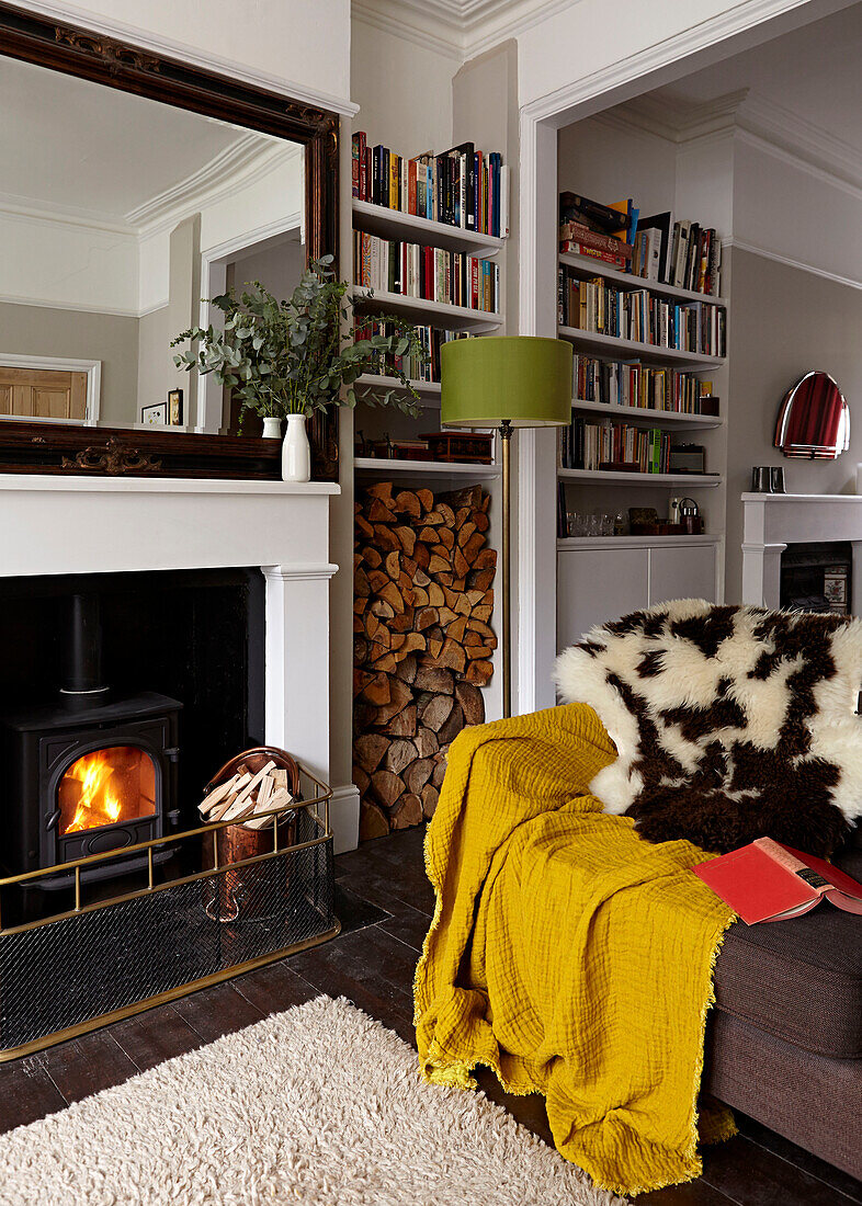 Fur throw on sofa at fireside in living room of contemporary London home   England   UK