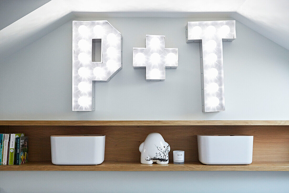 Buchstaben 'P' und 'T' über Holzregal im Schlafzimmer eines Londoner Stadthauses England UK