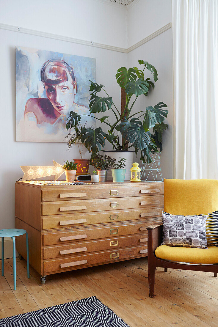 Yellow armchair with houseplant on sideboard in living room of Alloa home  Scotland  UK