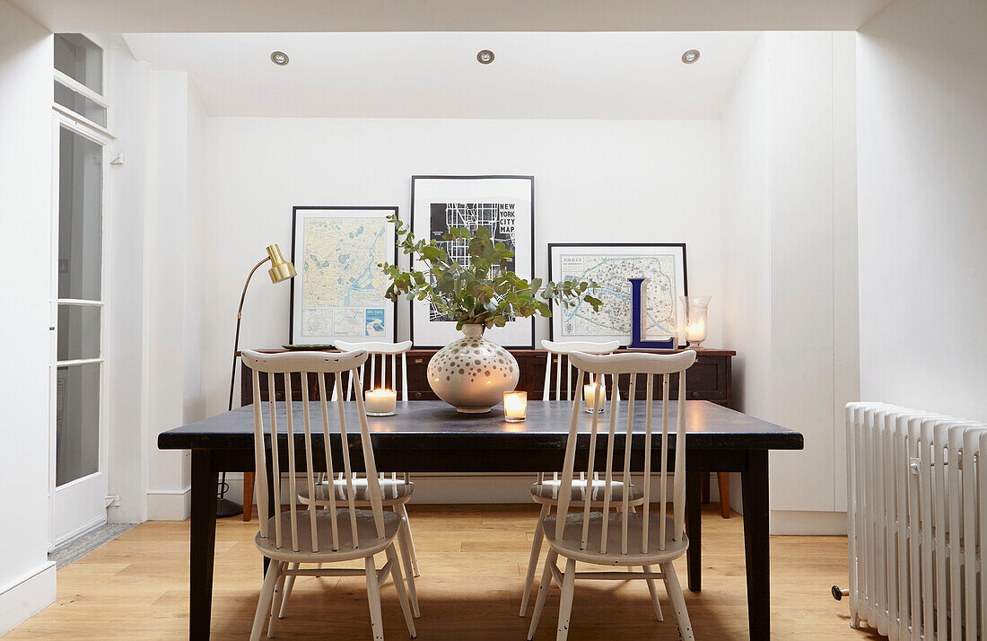 Blattarrangement auf Tisch mit weißen Esszimmerstühlen in einem Londoner Haus UK