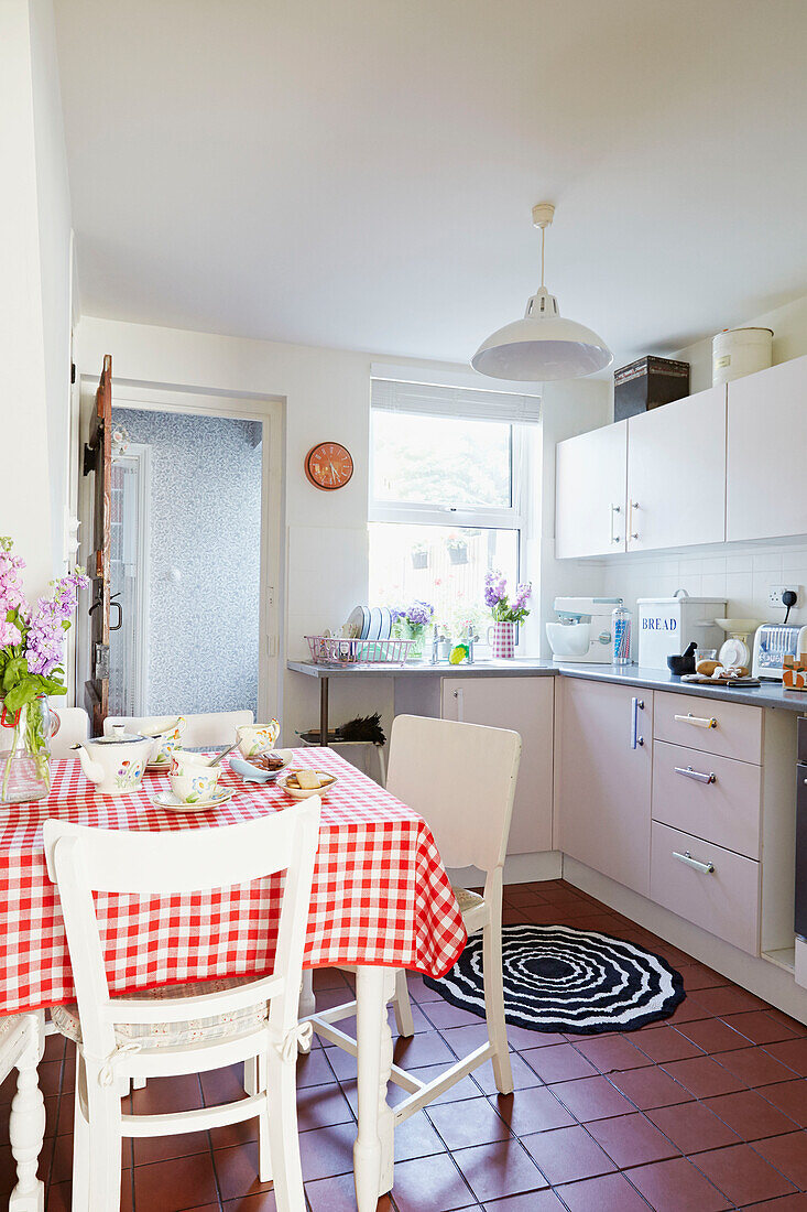 Rot-weiß karierte Tischdecke in der Einbauküche eines Hauses in Faversham, Kent, Großbritannien