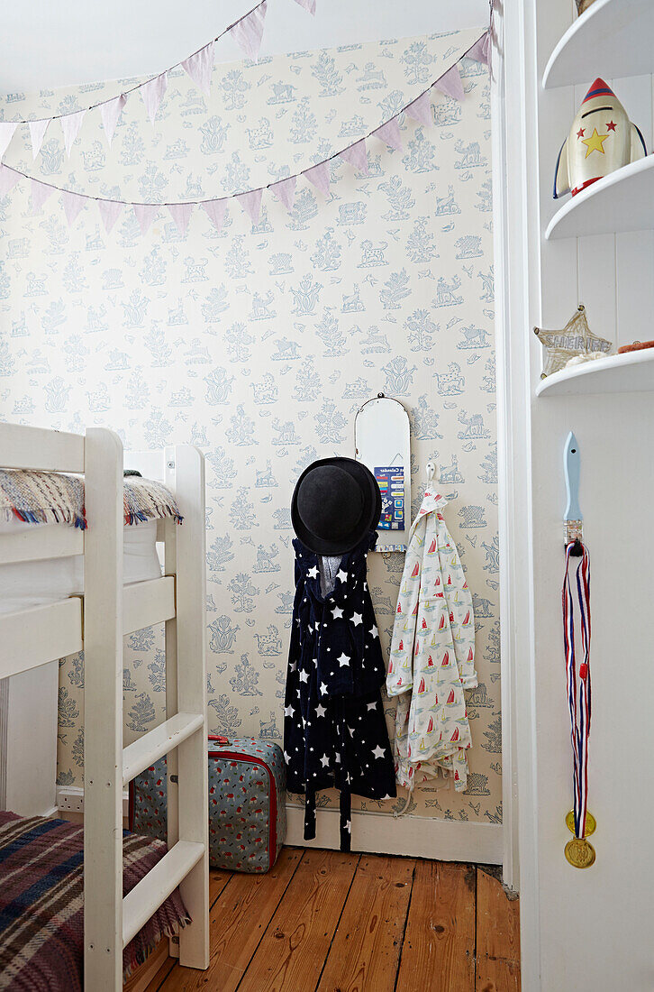 Bowler-Hut und Morgenmantel hängen unter einem Wimpel mit Etagenbett im Jungenzimmer eines Hauses in Faversham, Kent, UK