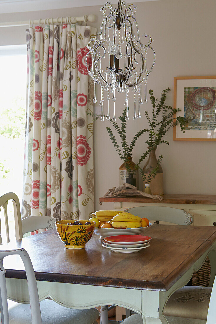 Obstschale auf Esstisch mit Glaskronleuchter in einem Haus in Bolton, Greater Manchester, England, UK