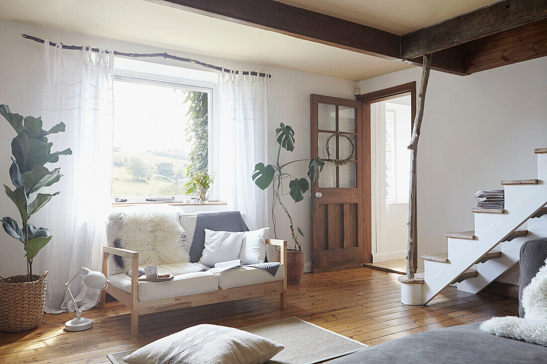 Zweisitzer-Sofa unter dem Fenster im Wohnzimmer eines Hauses in West Yorkshire UK