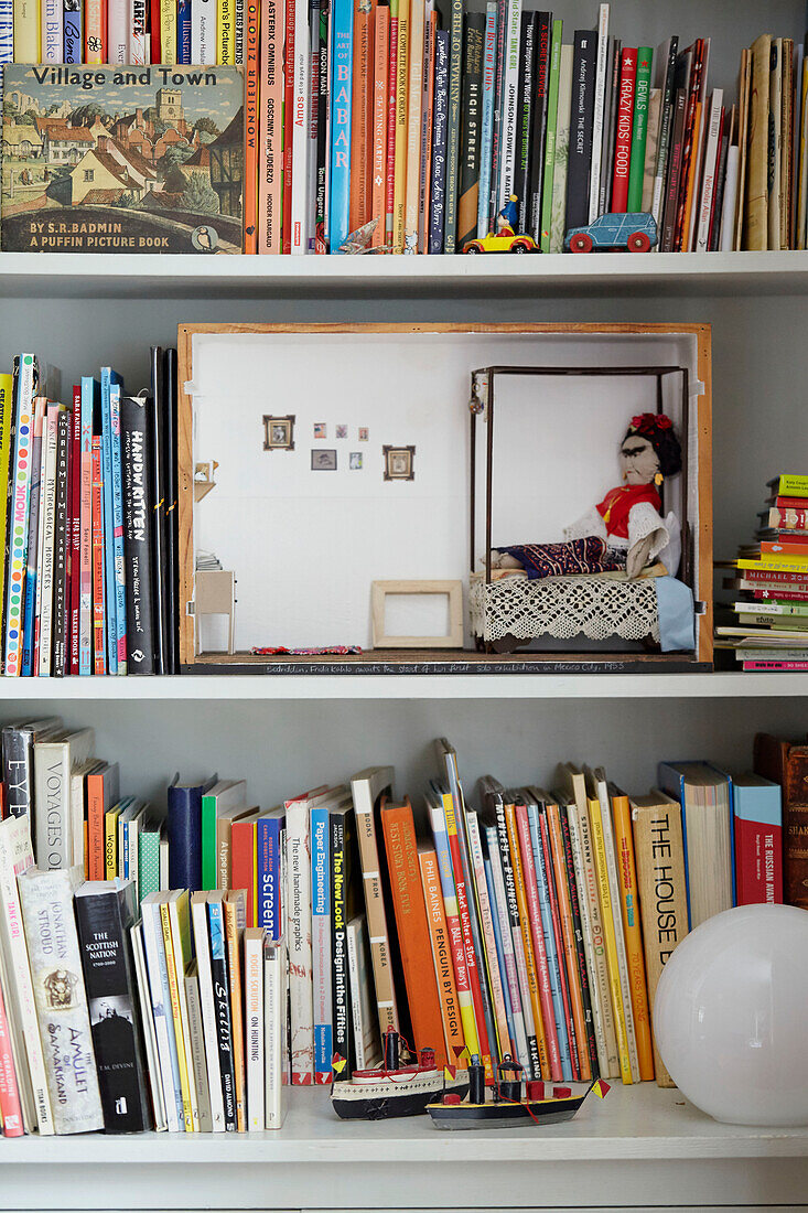 Puppenhaus und Bücher in einem Regal in Berwick Upon Tweed, Northumberland UK