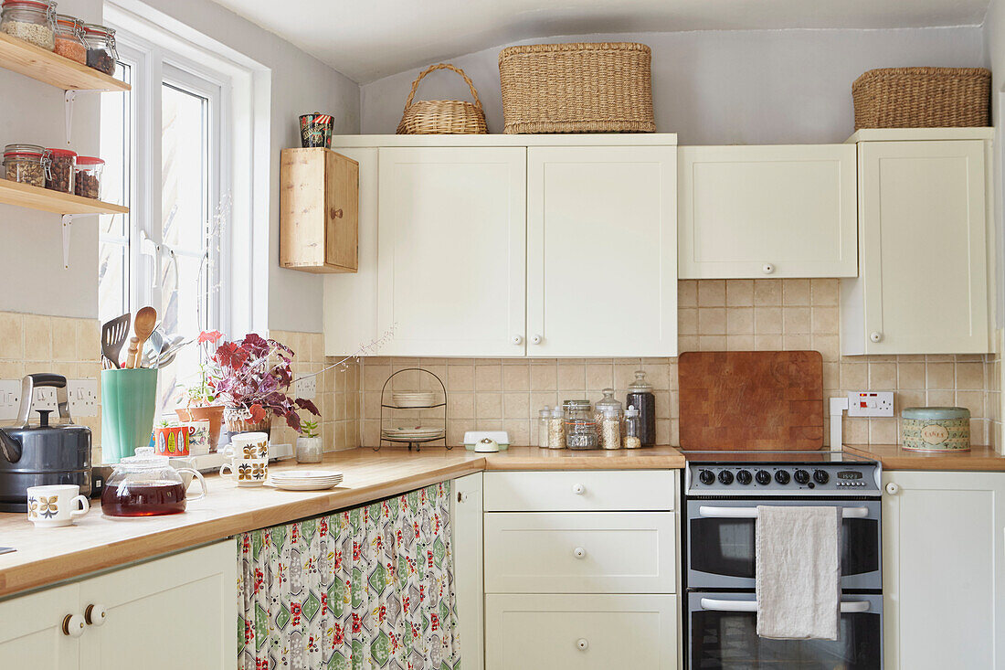Fabric curtain under workbench in cream  retro styled Berwick Upon Tweed kitchen  Northumberland  UK