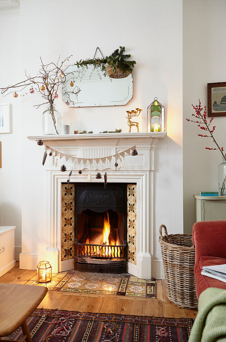 Christmas decorations on mirror above fireplace in living room of London home  UK