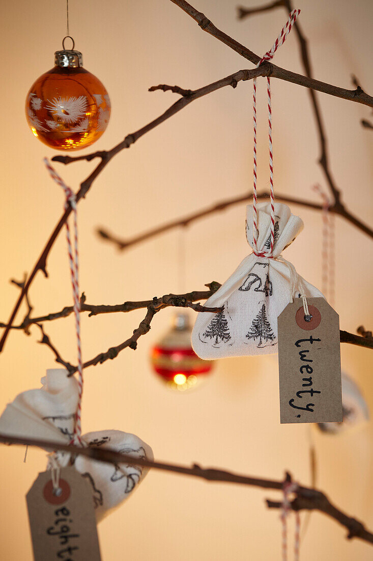 Handgeschriebene Etiketten mit Weihnachtskugeln auf Zweigen in einem Londoner Haus UK