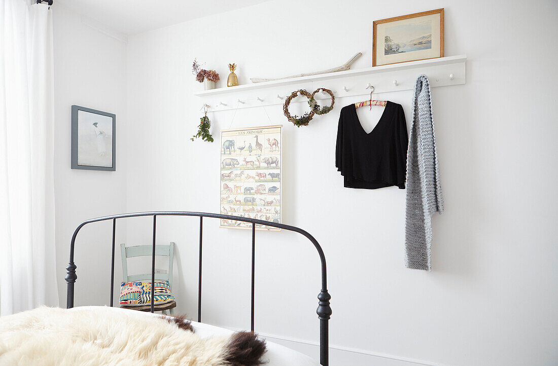 Top und Schal hängen in einem Zimmer mit metallgerahmtem Einzelbett in einem Londoner Haus UK