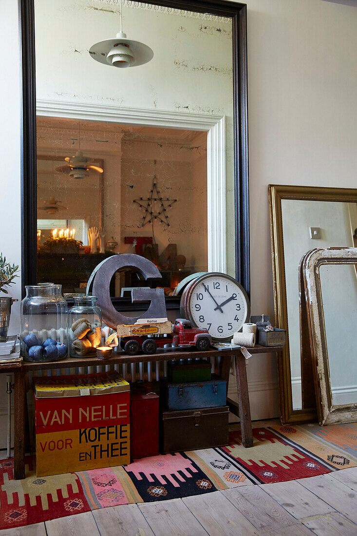 Buchstabe 'G' und Uhr mit einer Sammlung alter Ornamente und einem großen Spiegel in einem Flur in Rochester, Kent, Großbritannien