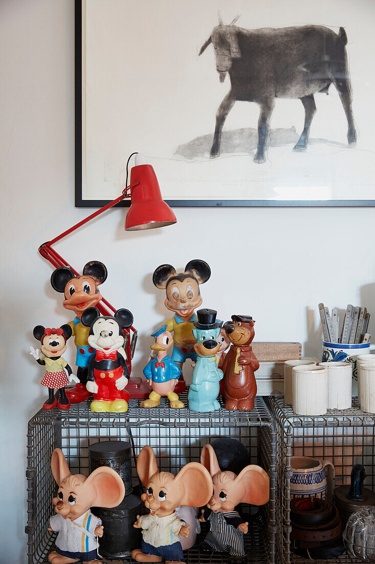 Sammlung von Plastikspielzeug in einer Metallkiste mit einem Kunstwerk einer Ziege im Haus in Rochester, Kent UK