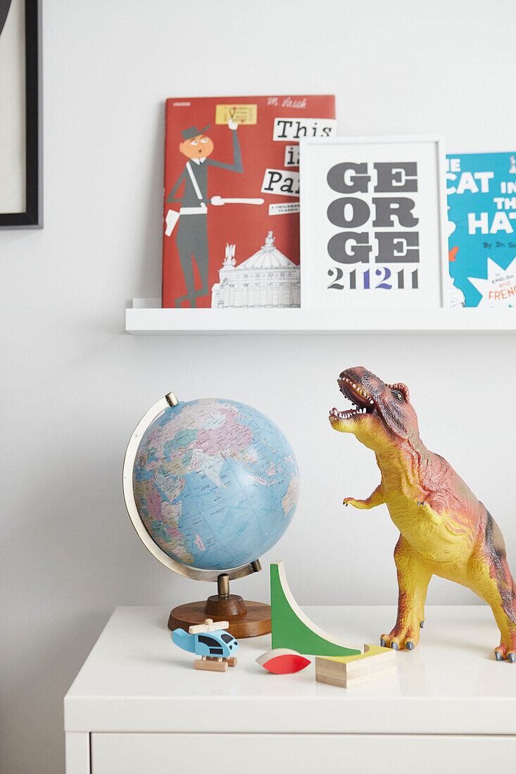 Dinosaurier und Globus mit Büchern auf Beistellschrank in Jungenzimmer London home UK