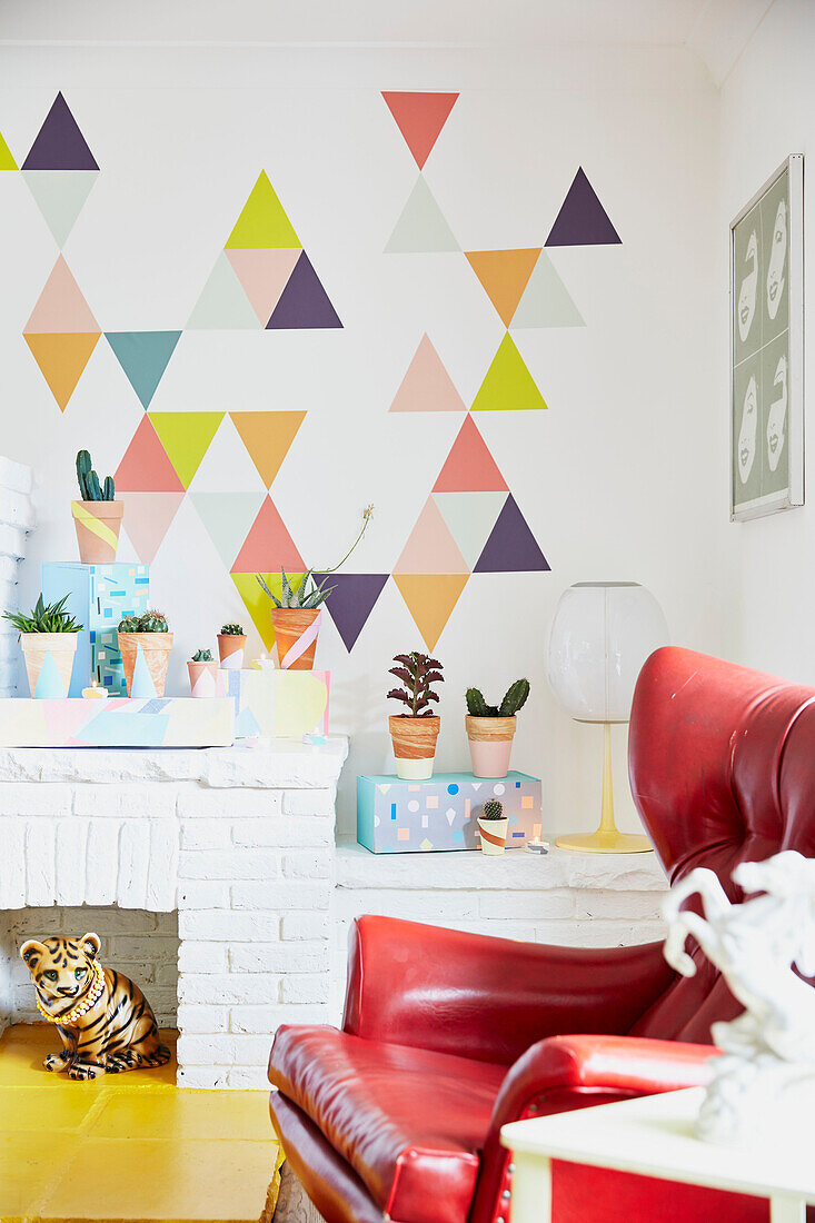 Red leather armchair and cacti with triangular patterned wall in East Riding of Yorkshire home  England  UK