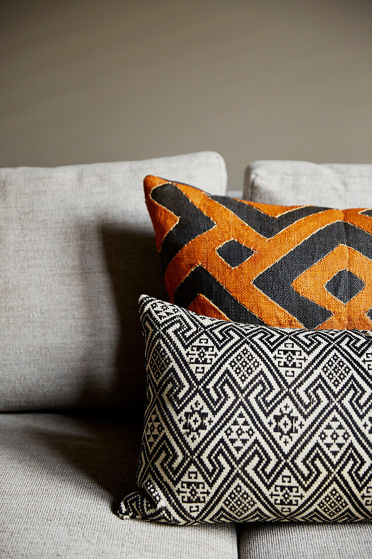 Orange and black geometrically patterned cushions in East London townhouse  England  UK