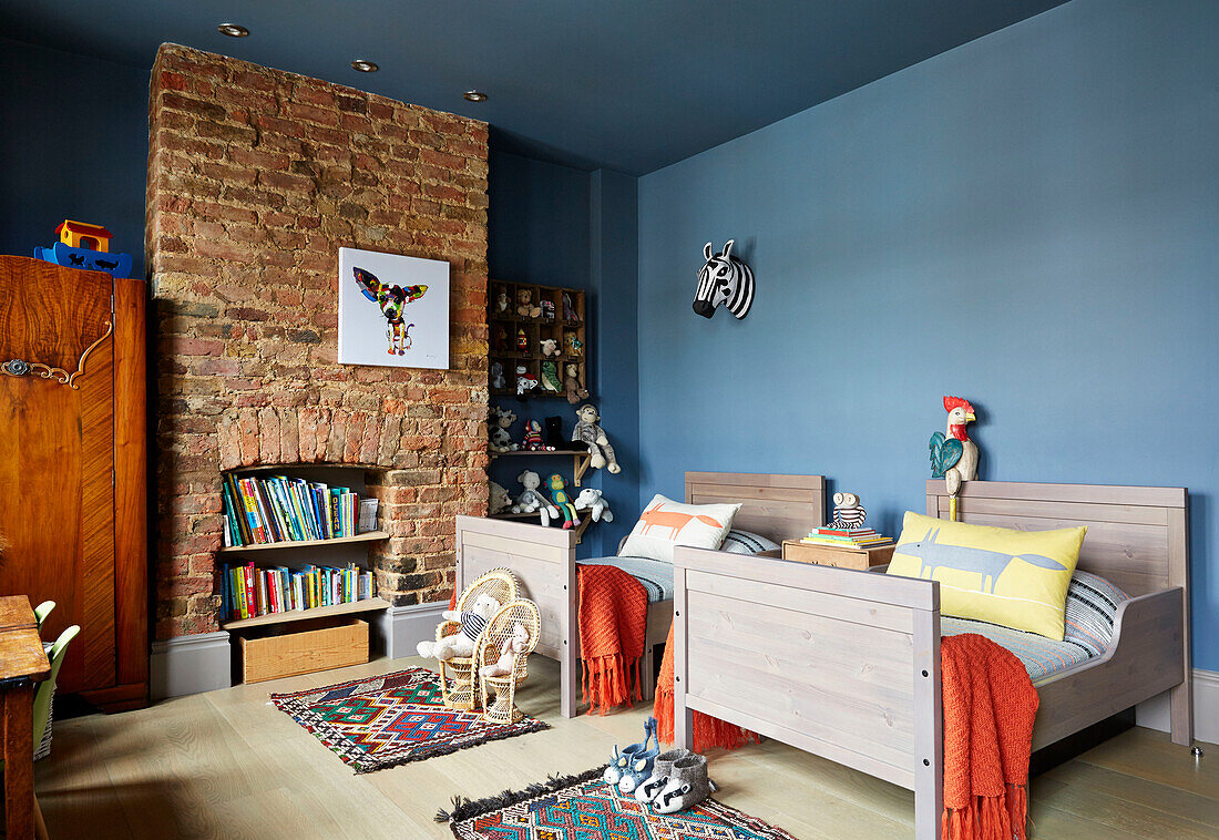 Twin beds with exposed brick wall in child's room  East London townhouse  England  UK