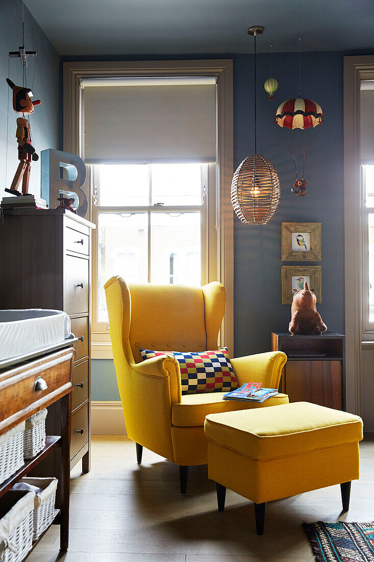Gelber Sessel und Hocker mit Sprossenfenstern in einem Stadthaus im Osten Londons England UK