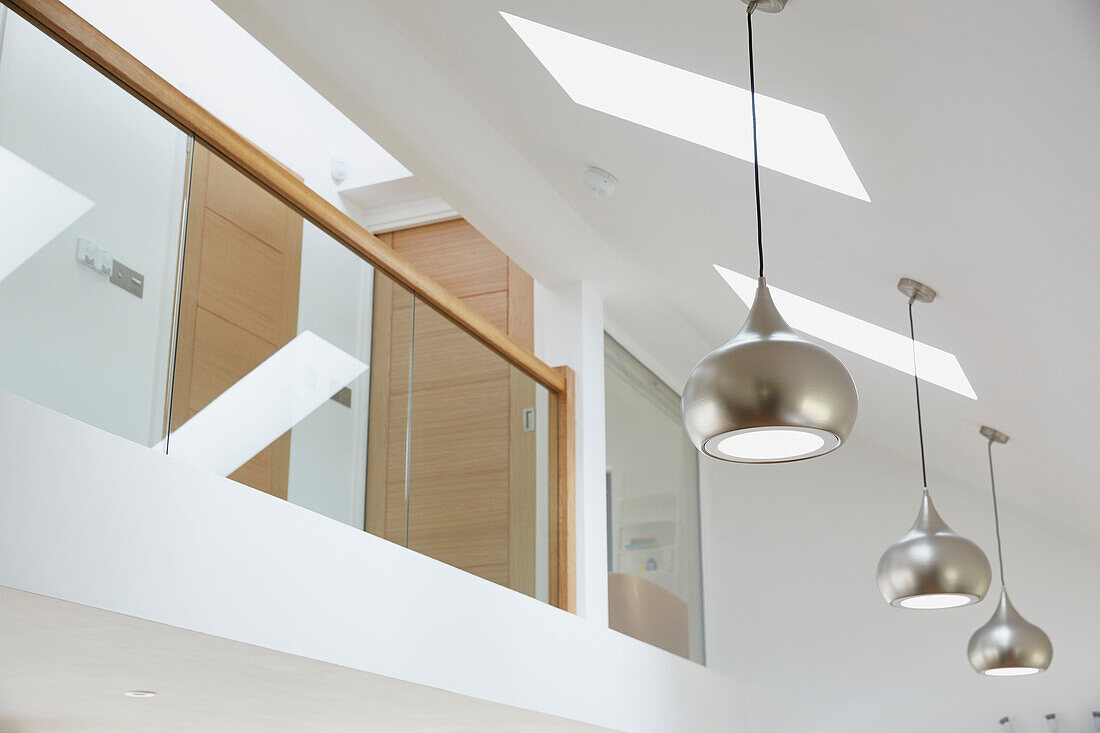 Silberne Pendelleuchten und Oberlichter mit Glas-Zwischengeschoss in einem Neubau in Devon, Großbritannien