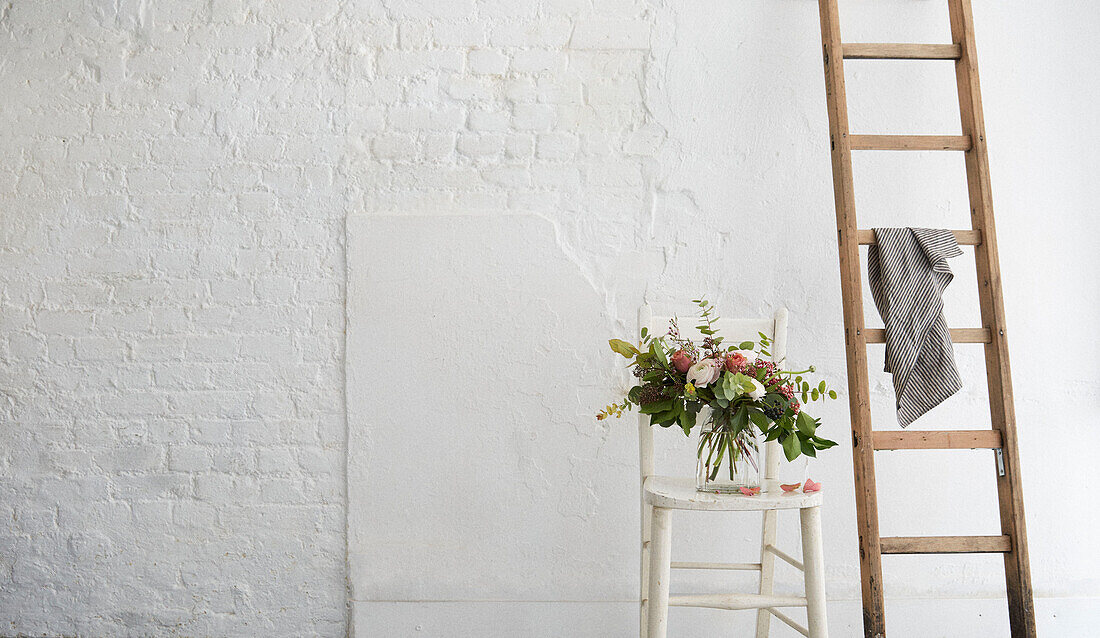Schnittblumen und Leiter in einem getünchten Londoner Atelier UK