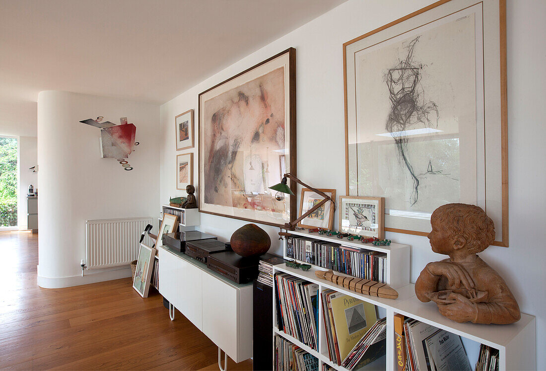 Plattenspieler auf Sideboard mit Vinyl und CDs und großen gerahmten Kunstwerken in einem Haus in Essex UK