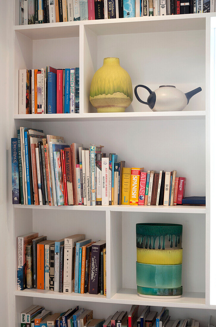 Bücher und Keramikvasen in einem Bücherregal in Essex, UK