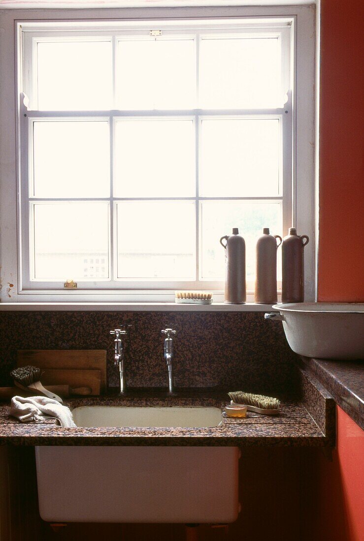 Küchenspüle mit Granitabtropffläche im Hauswirtschaftsraum am Fenster