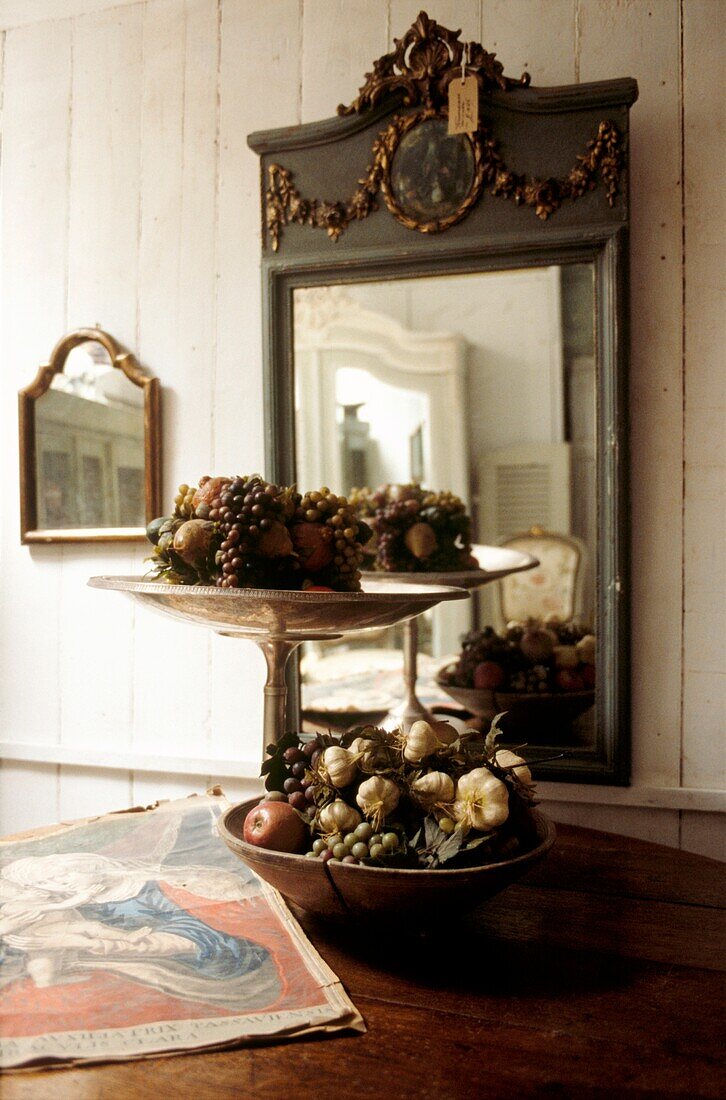 Still life of fruit and vegetables in front of decorative French mirror