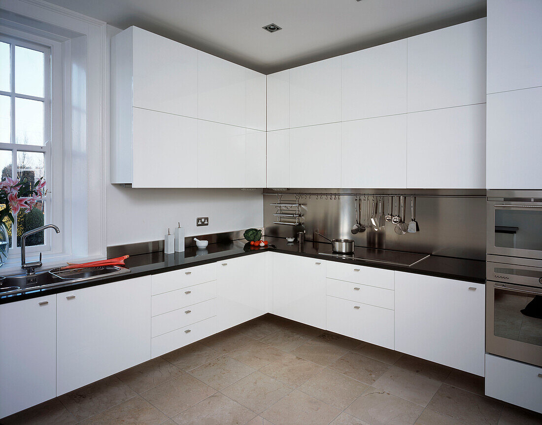 Modern white fitted kitchen with marble worktop