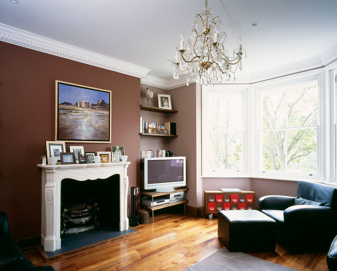 Wohnzimmer mit auberginefarbenem Anstrich und Marmorkamin