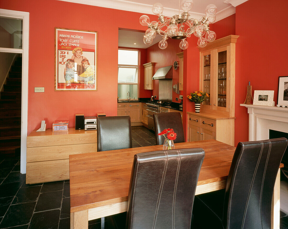 Esszimmer mit leuchtend roten Wänden und angrenzender Küche
