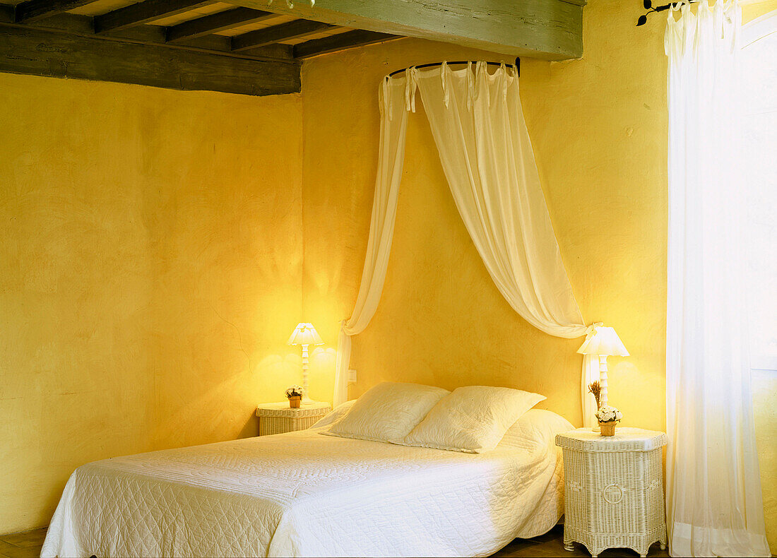 Sonniges gelbes Doppelzimmer mit Nachttischlampen und Vorhangvorhang