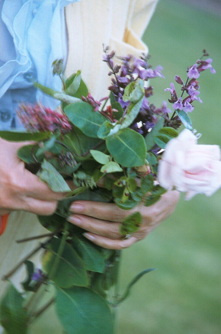 Close up of woman with fresh flowers picked from the garden