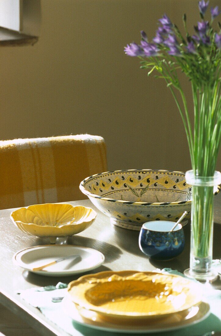 Gedeckter Tisch mit gelbem Porzellan und blauen Blumen