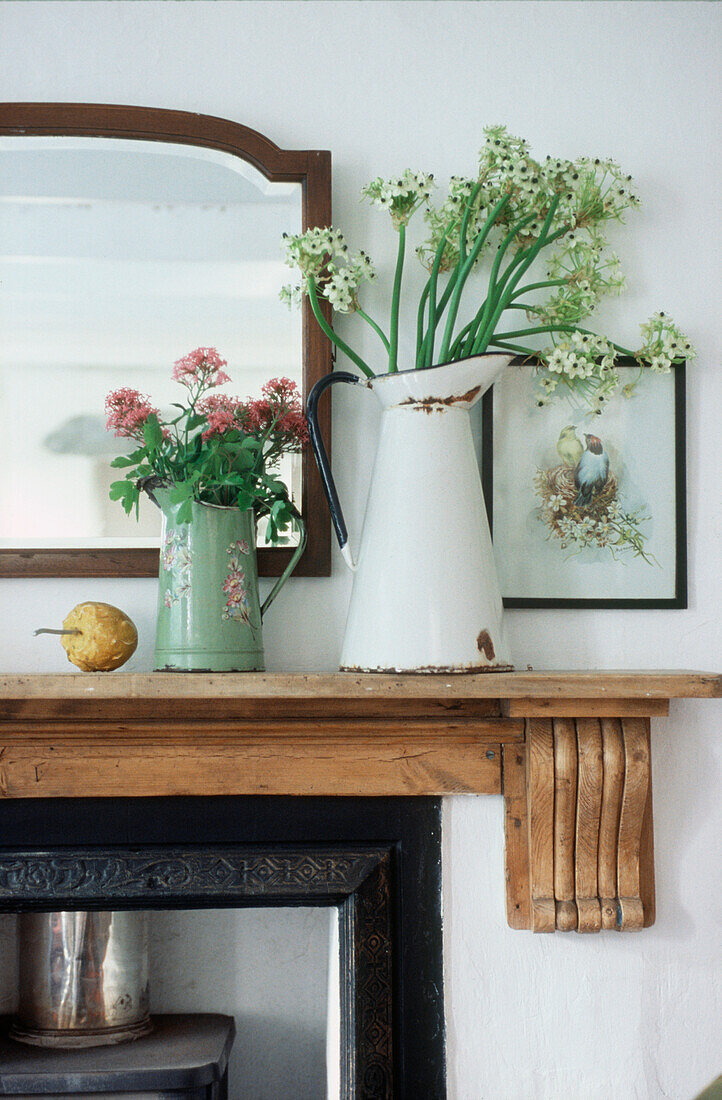Detail eines Kaminsimses im Wohnzimmer mit Schnittblumen in Vasen
